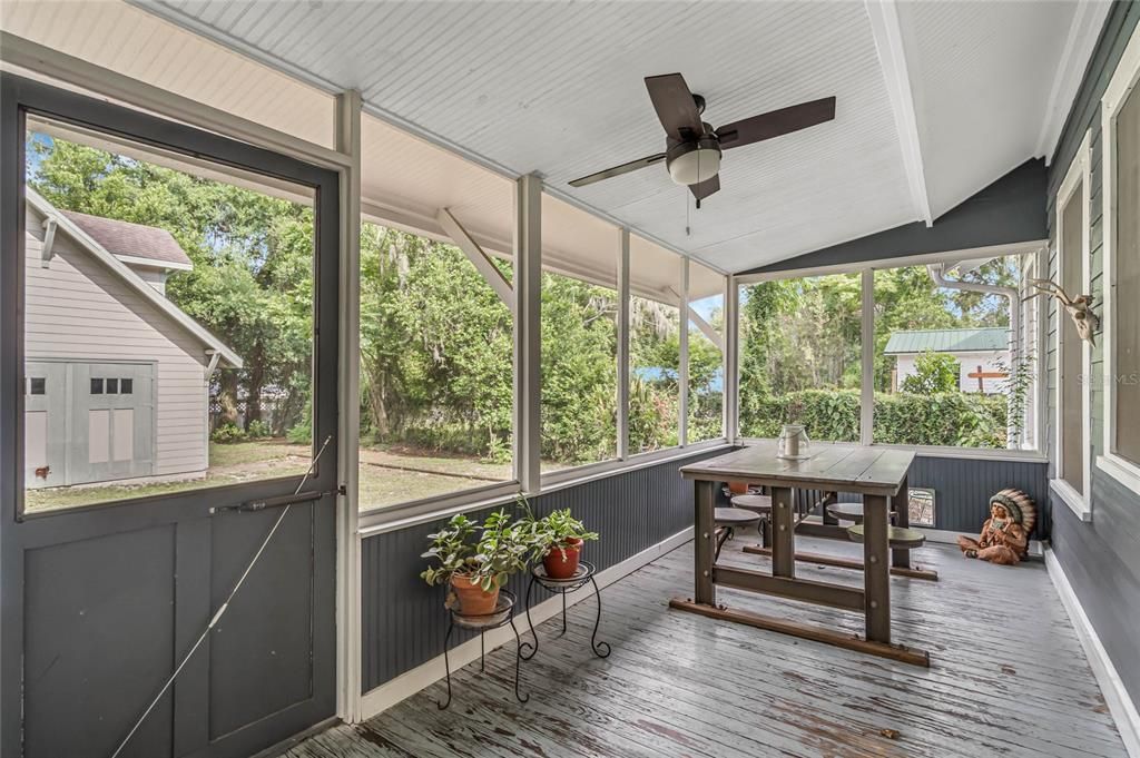 Back screen porch overlooking fenced backyard and two car garage