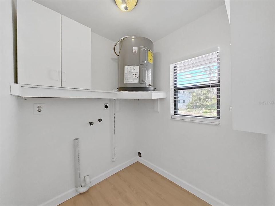 Closet off the primary bedrom with washer/dryer hookup and the 1st water heater