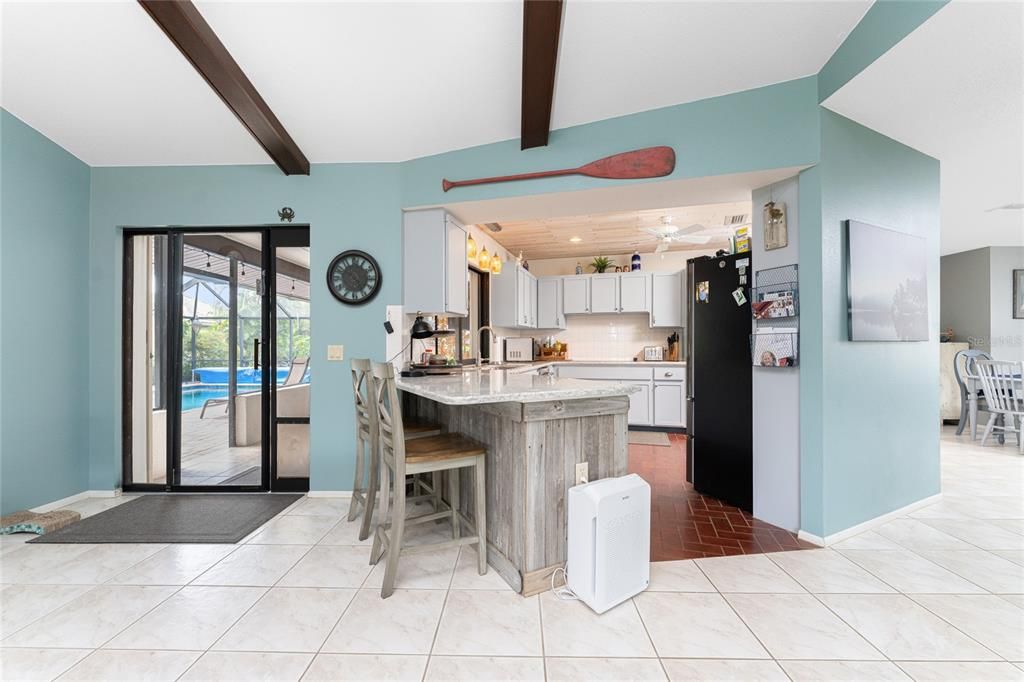 kitchen view with breakfast bar & sliders to lanai/ pool