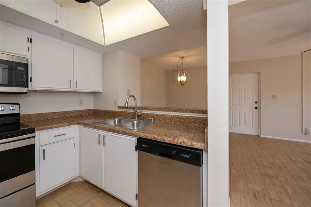 Kitchen has white cabinets & newer countertop