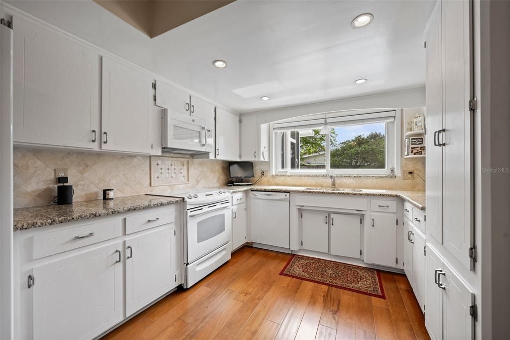 Kitchen is equipped with Granite Countertops and a window overlooking the Gorgeous Backyard