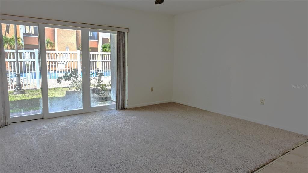 Another view of Living Room, storage closet on patio. View of pool