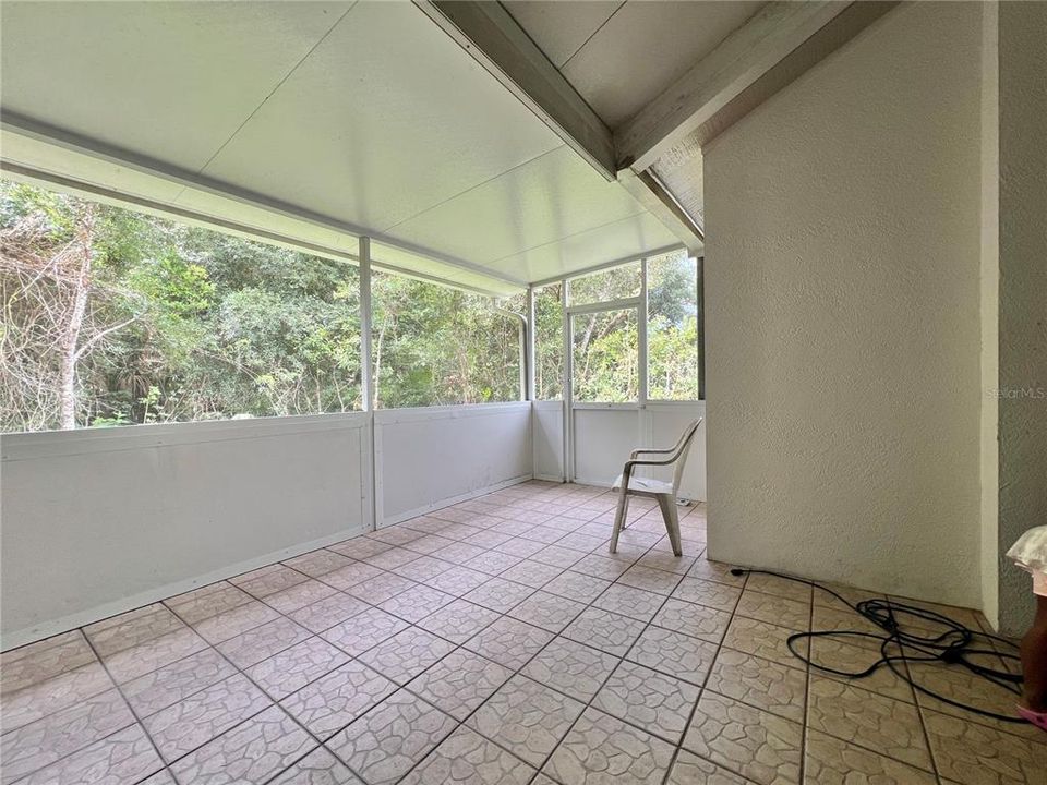 Screened-in back porch has ceramic tile flooring (small leak in porch roof at joint)  Two screen exit doors.