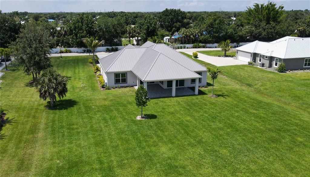 Rear aerial view of home and lot