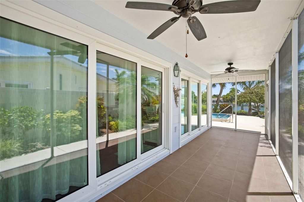 Screen enclosed porch off living/dining area & pool, with hurricane impact sliding doors.