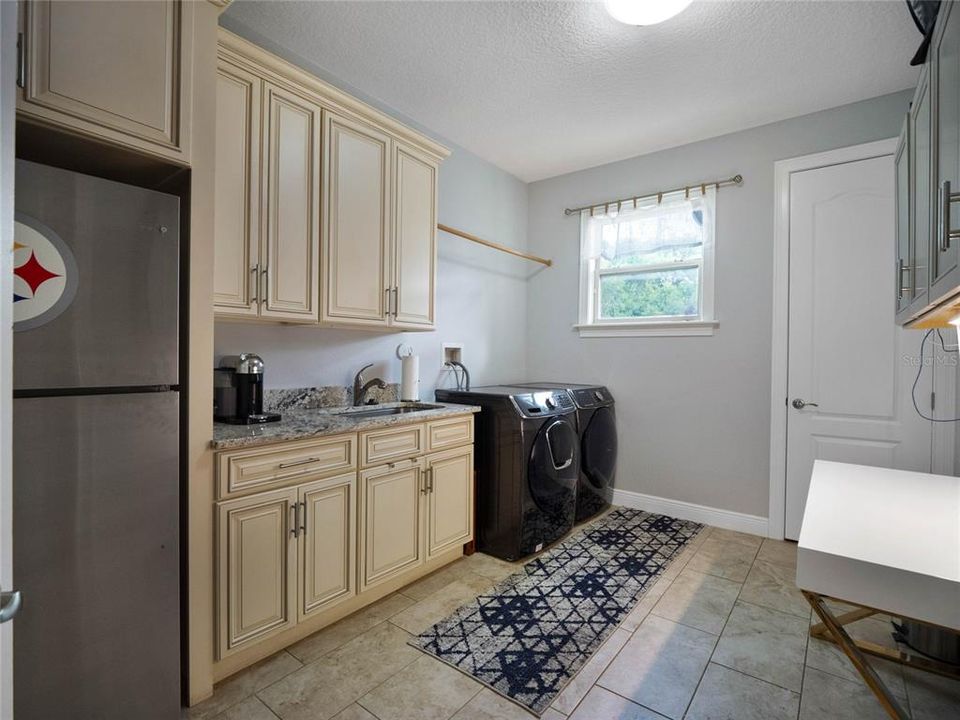Spacious laundry room with second refrigerator and second closet pantry.