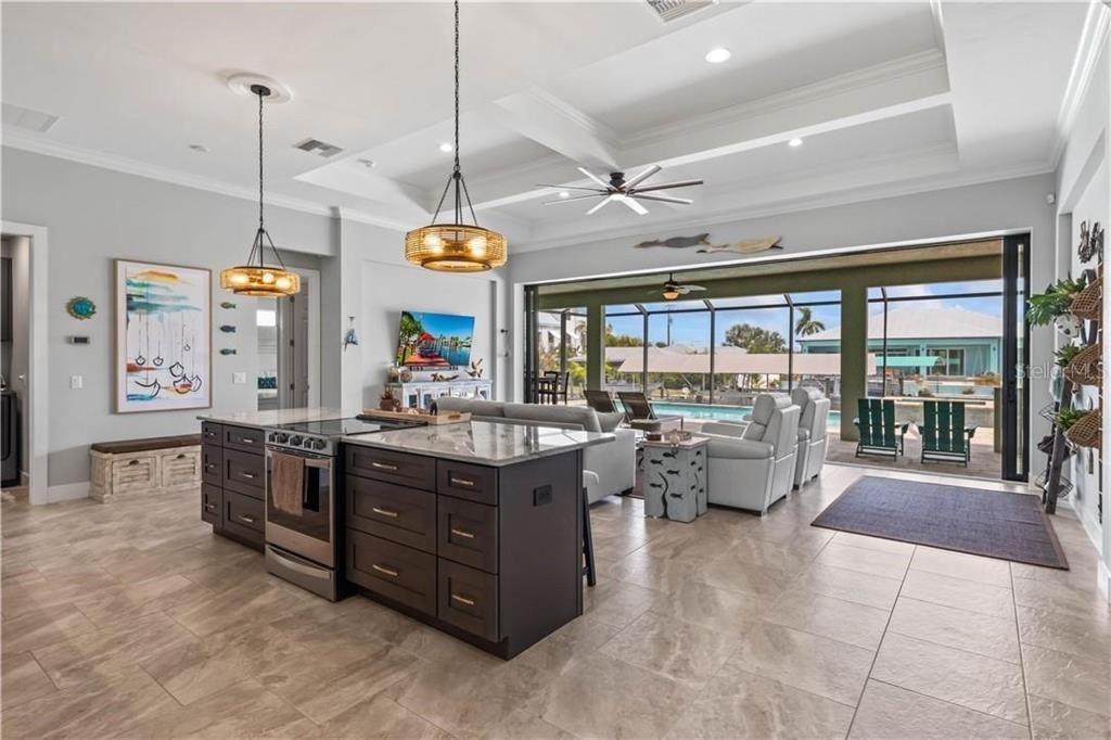 THIS KITCHEN!!!  An extensive kitchen island with custom lighting and upgraded induction stove.  Look at those views through the disappearing sliders - let your culinary creations come to life!