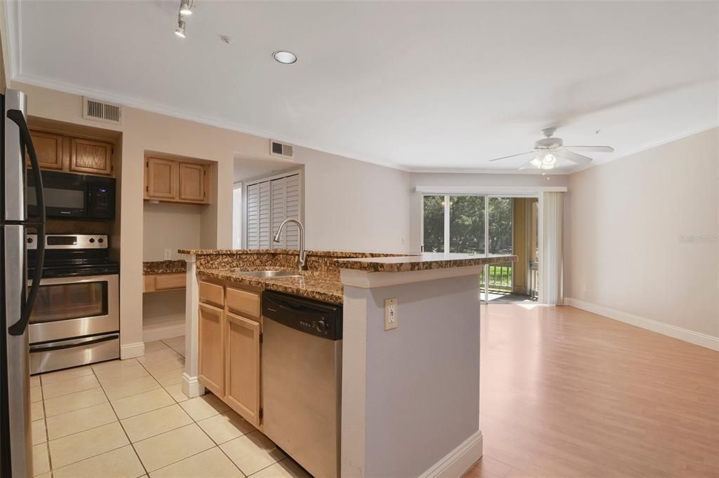 Central kitchen with stainless steel appliances and granite counters plus desk