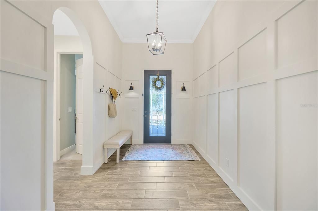 Bright entryway with custom woodwork walls