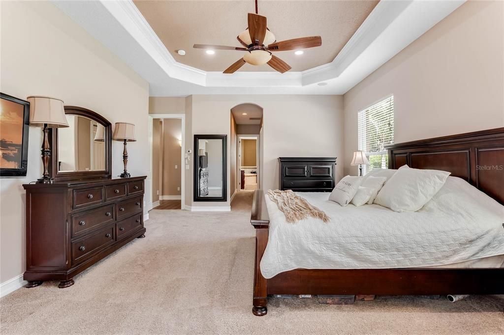 arge light filled primary bedroom with access to the screened in pool lanai.