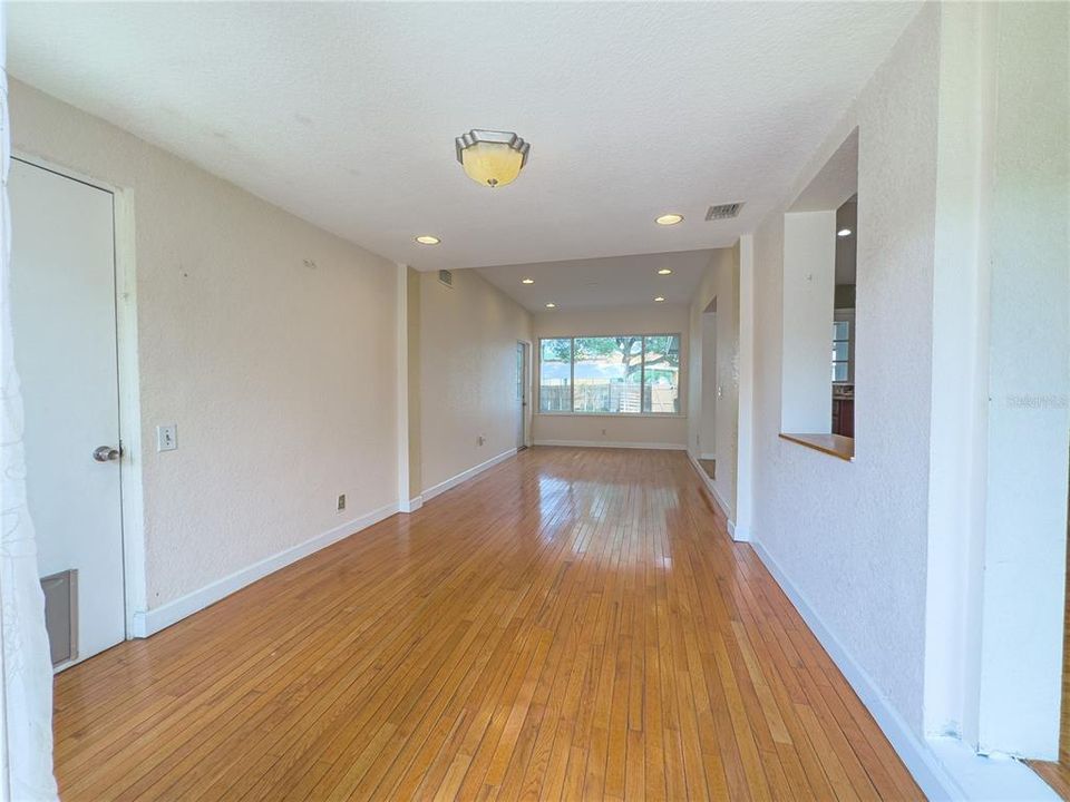 Great room view with door leading to garage to the left and beautiful polished floors...