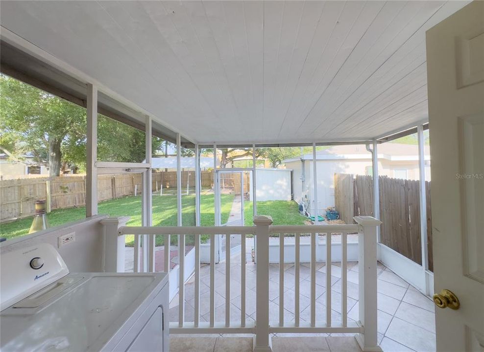 Enclosed screen home with combo utility room  with view of back yard that is big enough for a beautiful pool!