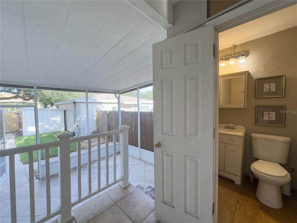 View of 1/2 bath and enclosed screen room/utility room as well as a view of back yard and completely separated and fenced for privacy, the ADU! (Additional Dwelling Unit) 1 bedroom/1bath built in 2018!