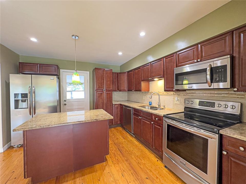 View of updated kitchen with beautiful cherry cabinets, stone cabinets and stainless steel appliances...