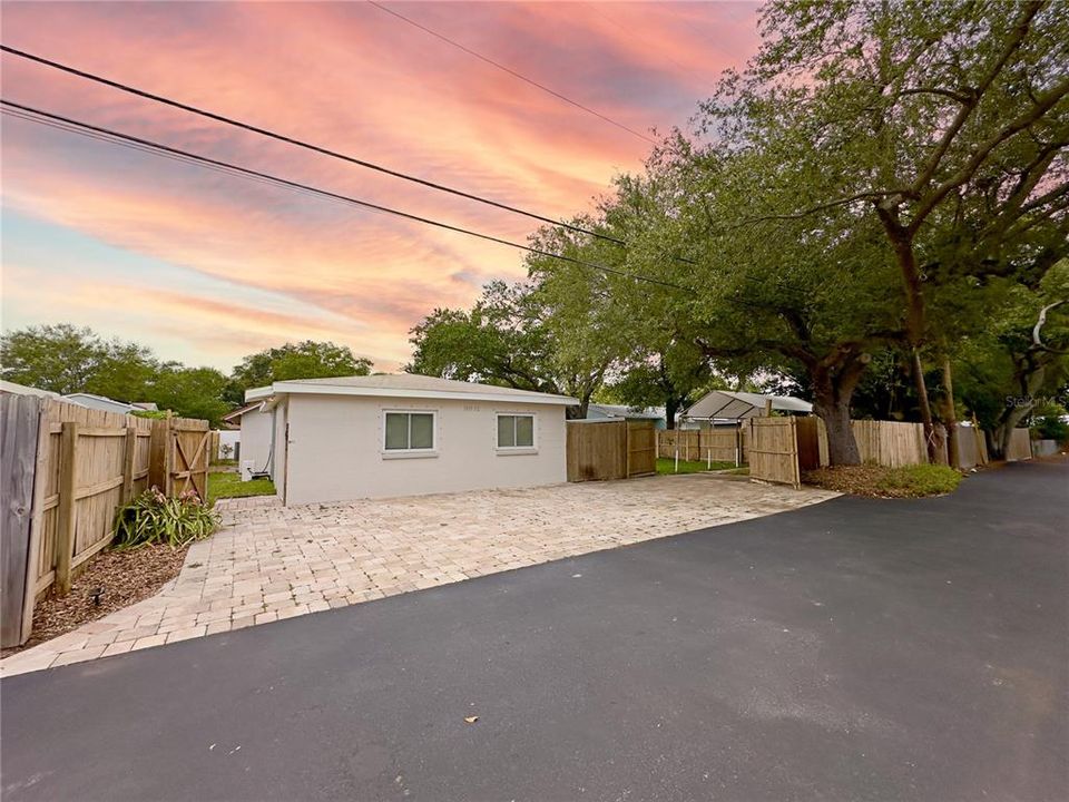 View of rear of property with the parking area with beautiful pavers for the ADU completely fenced in yard...