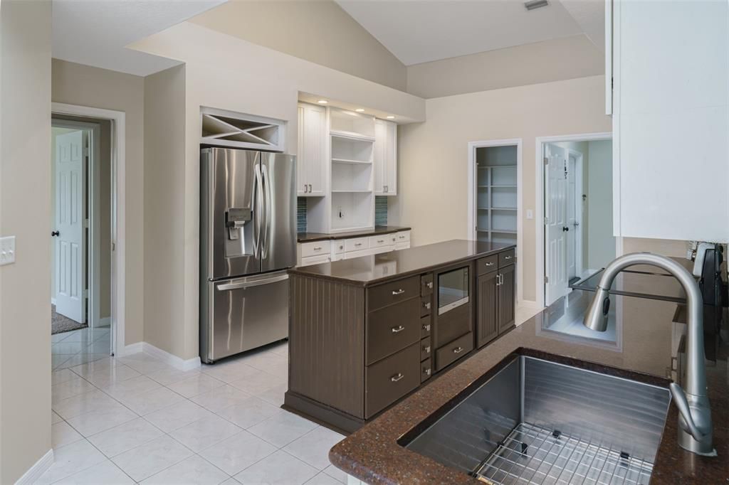 Kitchen with entry way to 3 secondary bedrooms and 2 bathrooms and doorways to walk-in pantry and laundry room in the background.