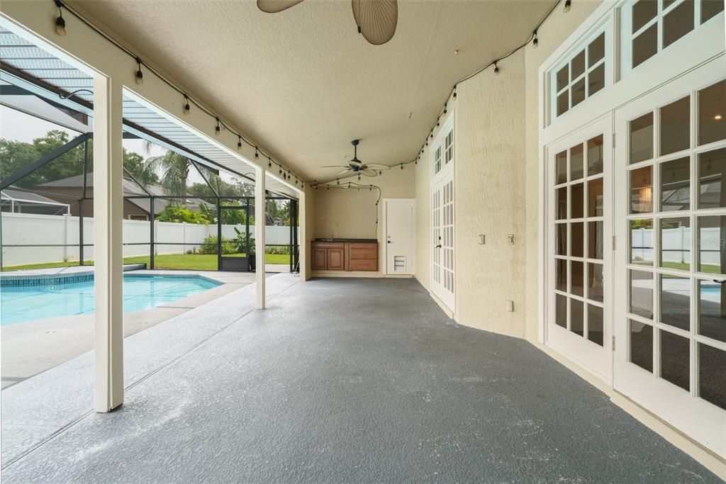 Large, covered lanai area with sink and cabinets.