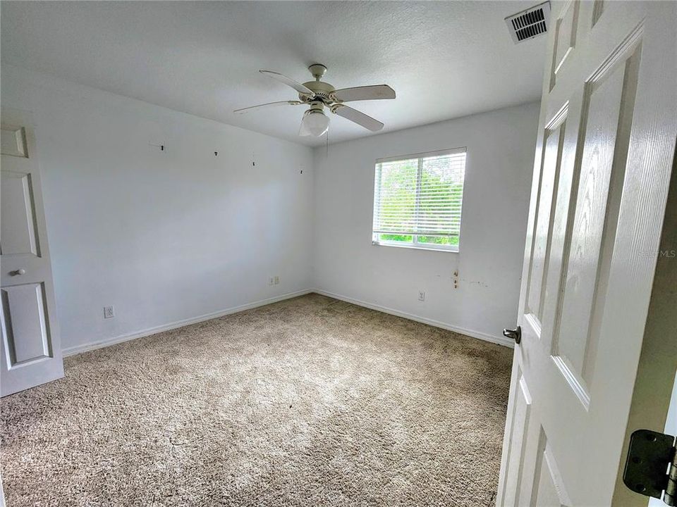 bed 3 with lake view and 6 panel door.  Every bedroom has a ceiling fan.