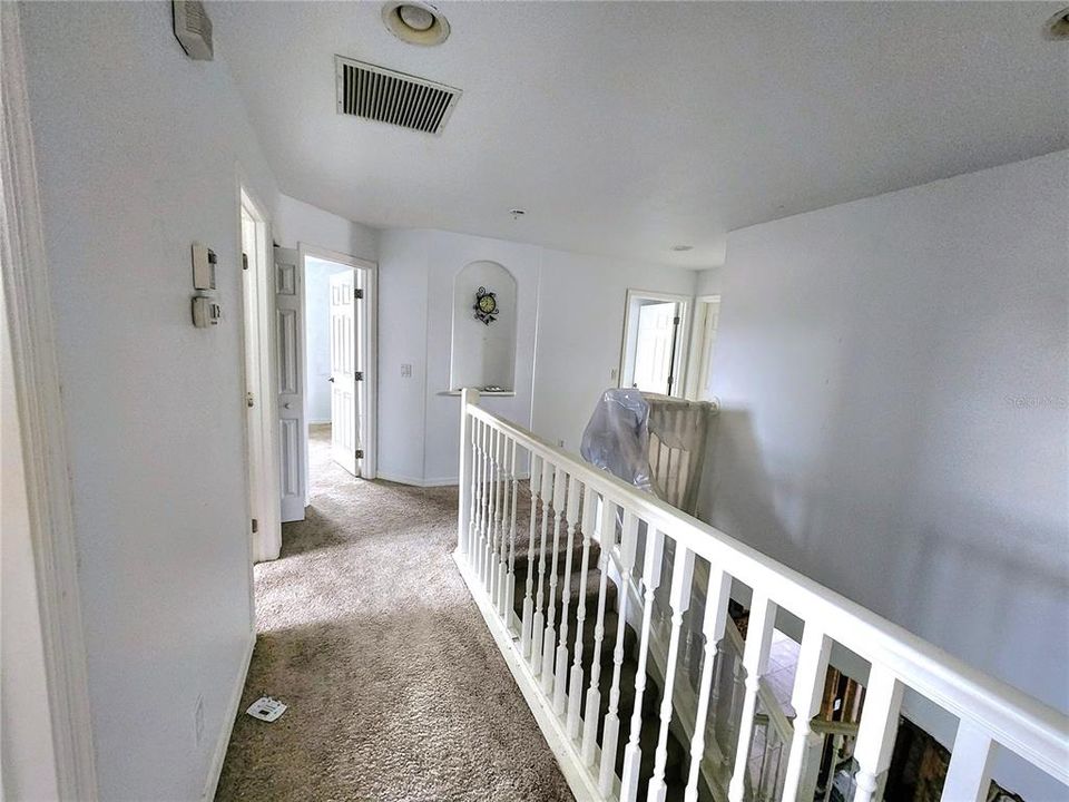 top of the stairs to the right is Master bedroom and a den (or possible 5th bedroom). Hallway and bedrooms all are carpeted. Each bedroom has 6 panel doors and a ceiling fan.