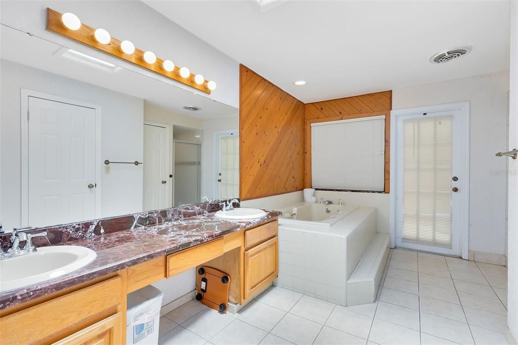 An equally spacious ensuite bath includes two additional closets, dual sinks, a luxurious garden tub, and a shower.