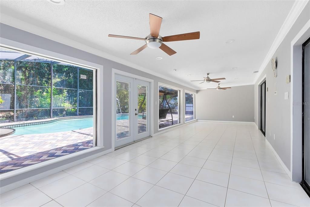 This expansive Florida room, seamlessly accessible from both the family room and kitchen.