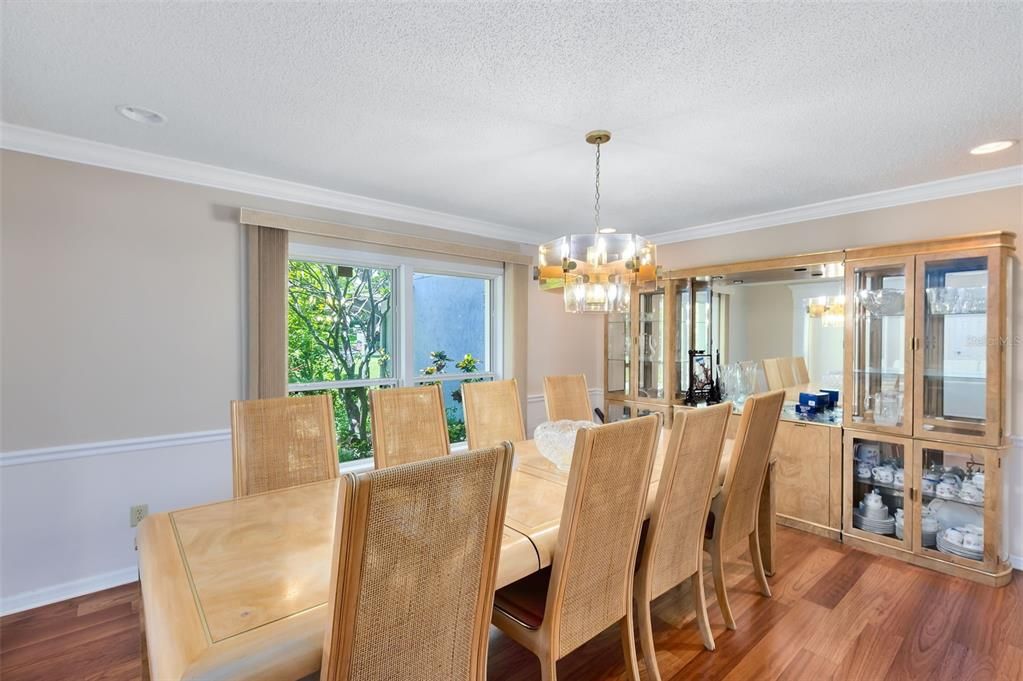 A formal dining room features crown molding and chair railing.