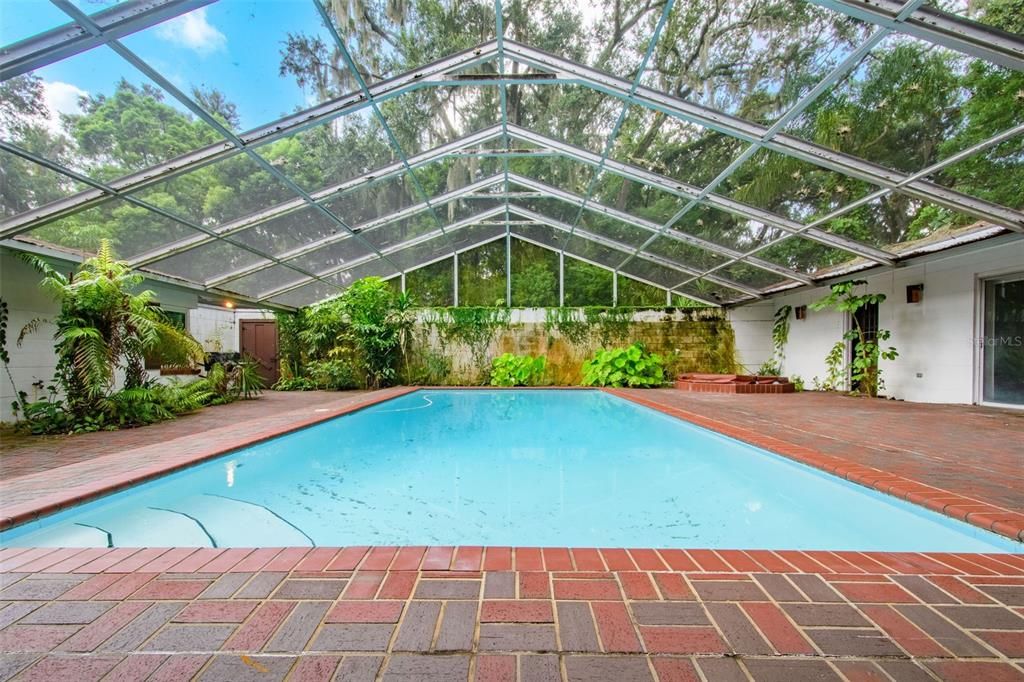 The large screen enclosed pool is tucked into the center of the "U-Shaped" home.