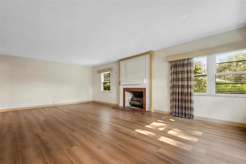 The main living area has a fireplace, wood laminate flooring and . . .