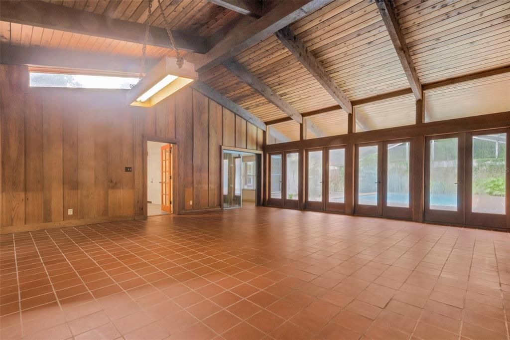 This room has a vaulted tongue & groove wood ceiling with wood beams.