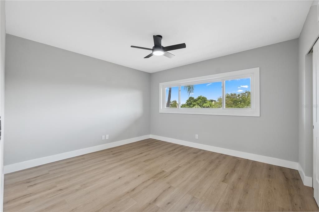 Second guest room with huge window for natural light , large closet and new ceiling fan