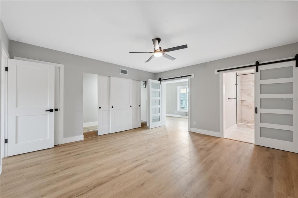 oversized primary suite with custom barn slider doors into the ensute bathroom and another  separate door leading into the bonus room at the back of the unit , shared large closet and convenient laundry hookups in this room
