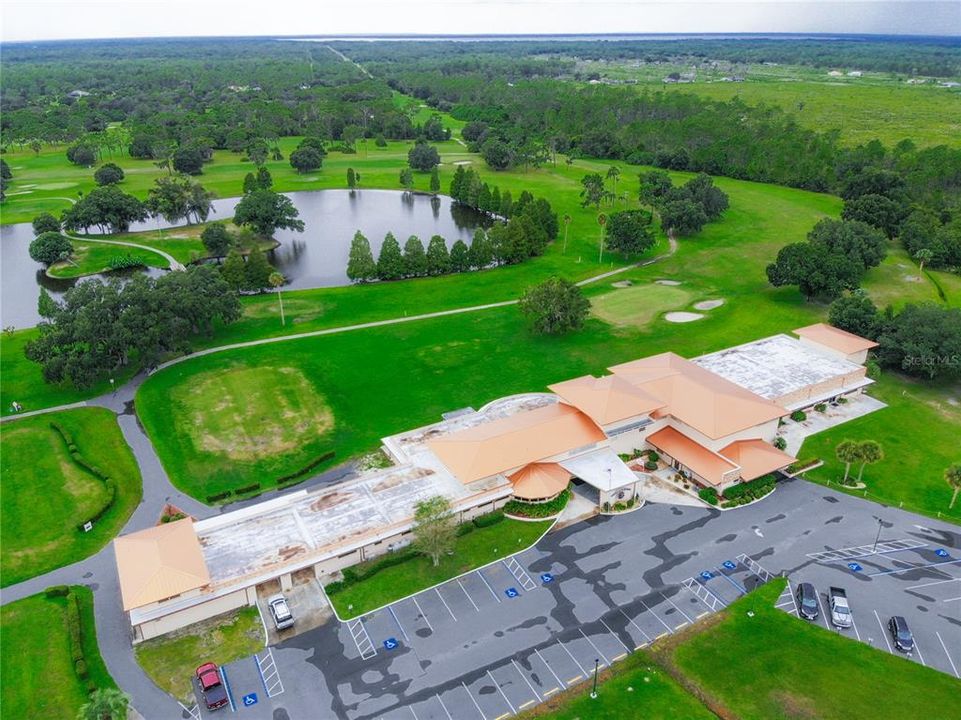 Aerial view of the clubhouse, golf course, tennis courts, and parking lot.