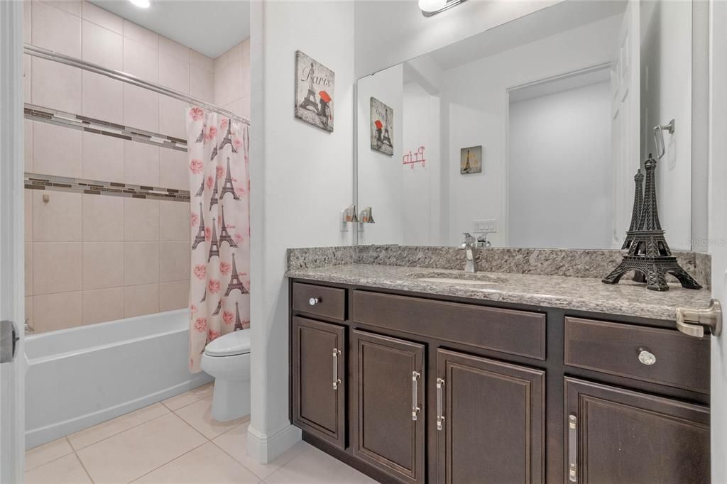 Bathroom 3 features a single sink with granite countertops and ample counter space, perfect for the budding makeup artist or anyone needing extra room for personal grooming essentials.