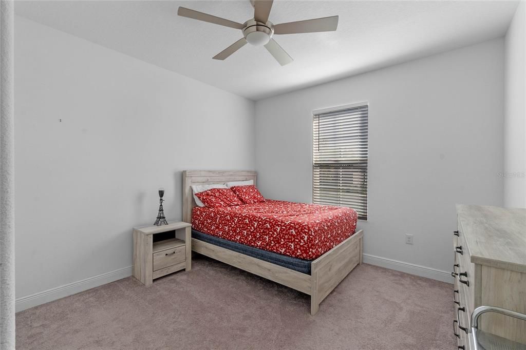 Bedroom 2: All bedrooms feature ceiling fans, ample closet space, and soft carpeting for comfort and relaxation.