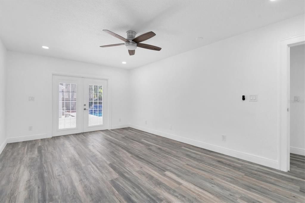 Primary Bedroom Featuring French Doors To Access Backyard Patio and Pool