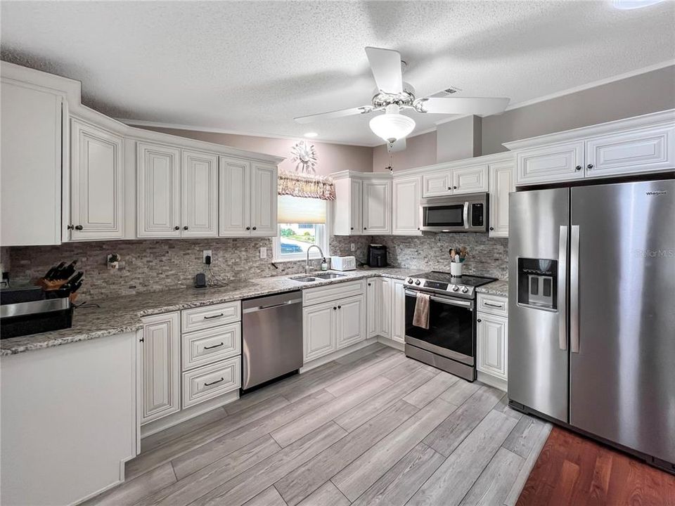 Newly updated kitchen featuring new cabinets, granite countertops, stainless steel appliances and laminate flooring