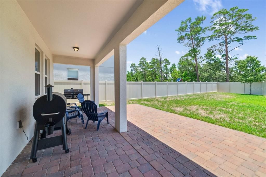 The extended paver lanai is the perfect spot to cookout or relax and unwind overlooking a sizable yard FULLY FENCED for added privacy.