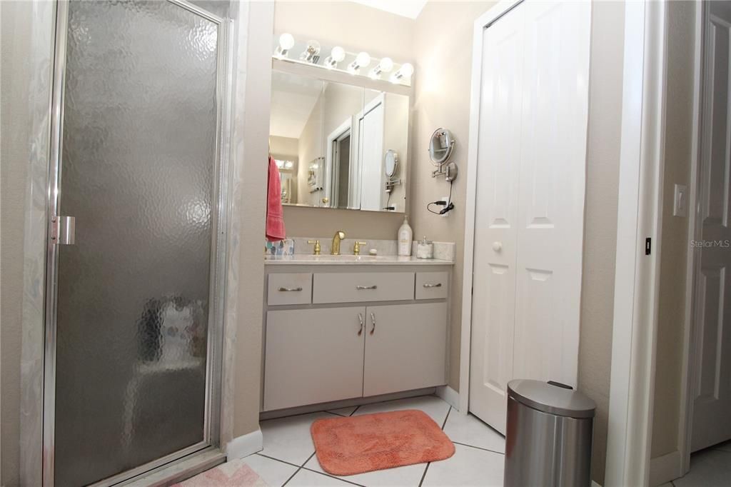 Primary Bathroom- Walk-in Shower with glass door and other vanity and linen closet.