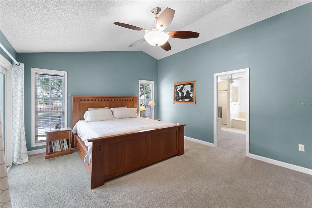 primary bedroom with vaulted ceilings and abundant natural light