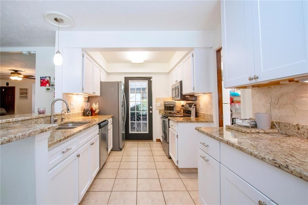 Lots of cabinets and big deep sink. Door leads to the garage.