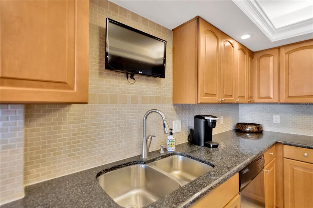 Notice the striking complimenting backsplach. granite countertops and cathedral designed cabinetry.