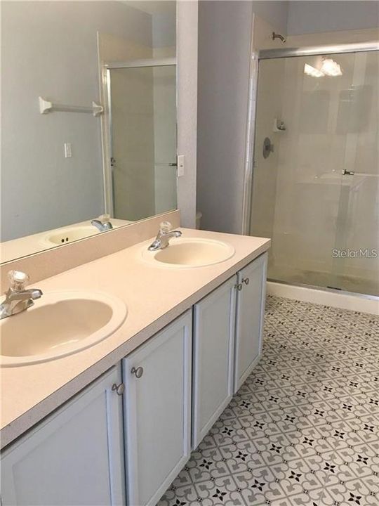 master bath with double sink vanity and shower stall