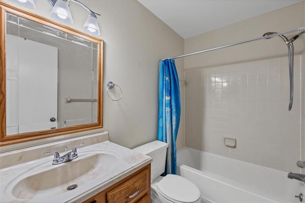 Guest bathroom with tub shower combo, vanity and toilet at 3862 59th Ave. W, Bradenton FL 34210