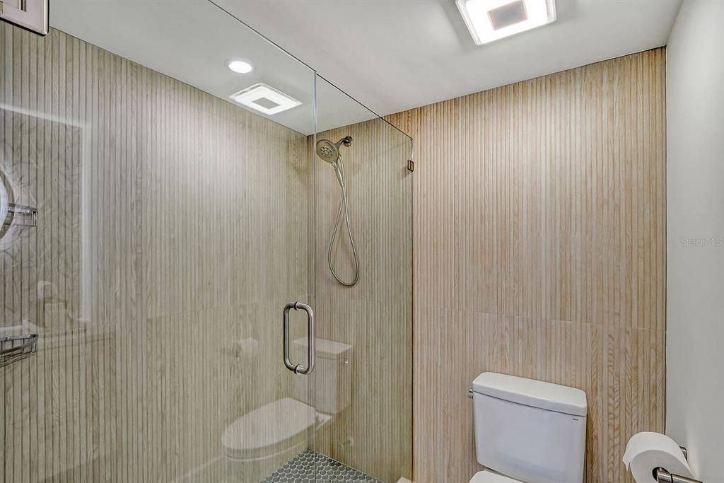 Guest bathroom - Unique porcelain tile shower wall extends out