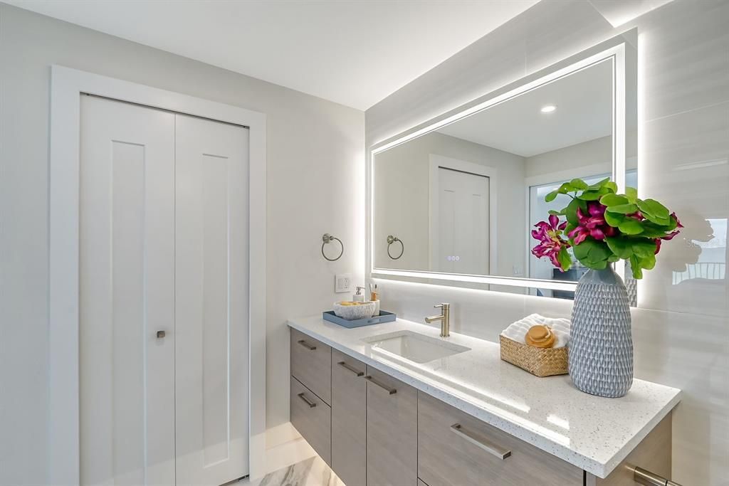 Primary bathroom with colorchanging touchlit mirror - looking toward walk-in closet