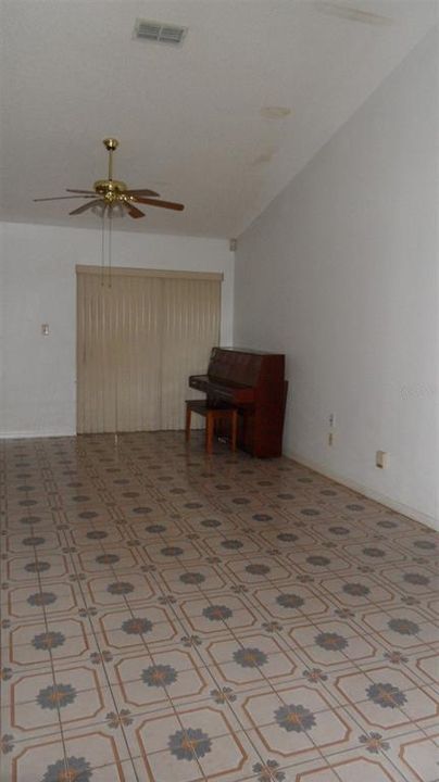 Family room with vaulted ceiling and sliding glass doors to enclosed patio