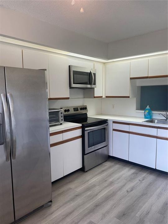 Eat in kitchen is equipped with stainless steel appliances, including a dishwasher