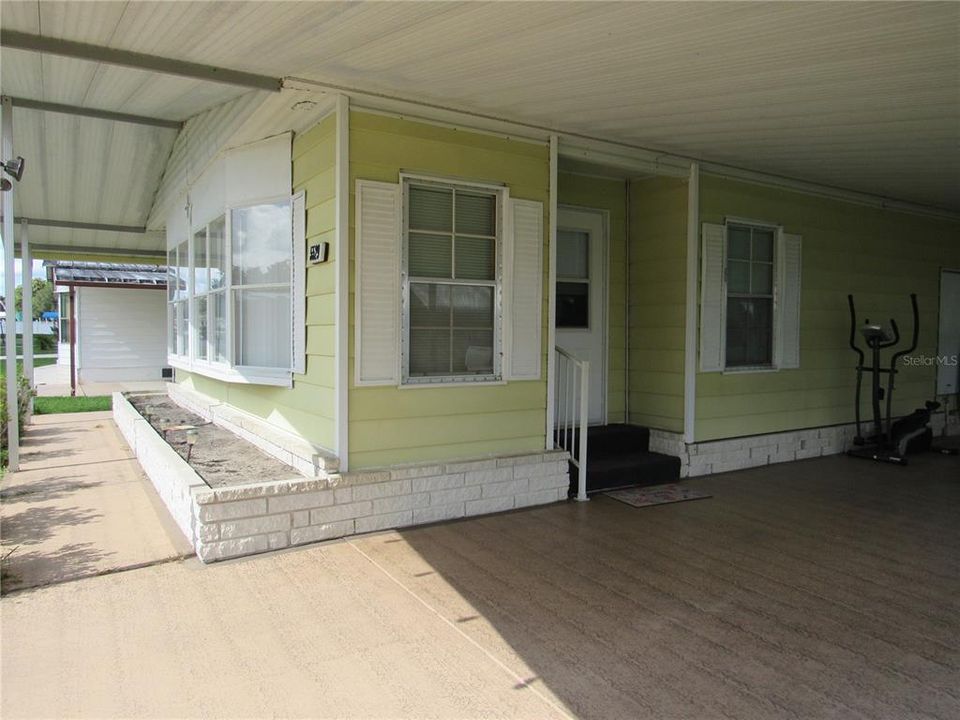 Covered front sidewalk, brick front planter, Driveway & carport.