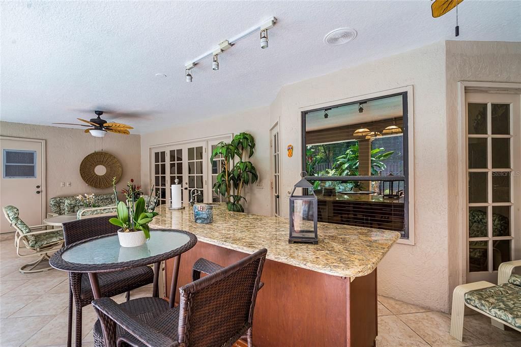 lanai with built-in bar and ample seating, overlooking a sparkling pool and spa