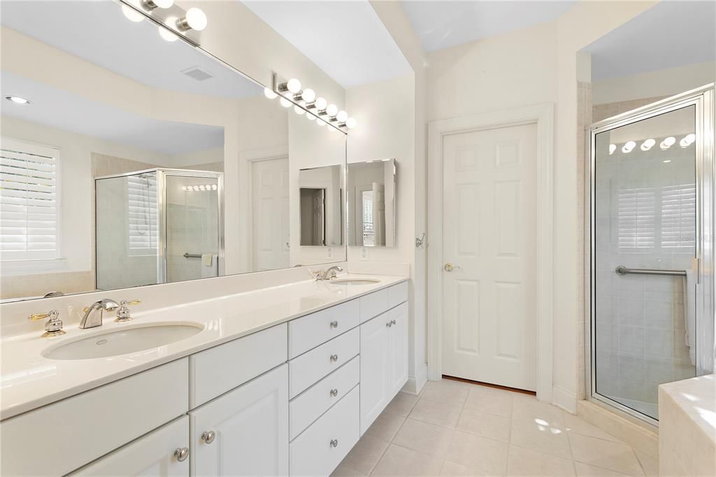 The primary bathroom features dual vanities, large shower and soaking tub